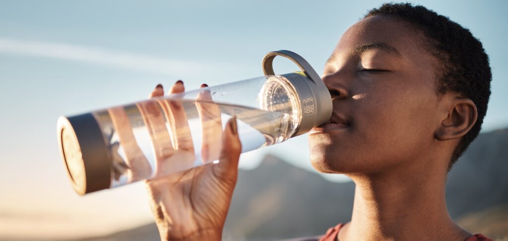 Fitness, black woman and drinking water bottle after training workout, exercise and outdoor cardio