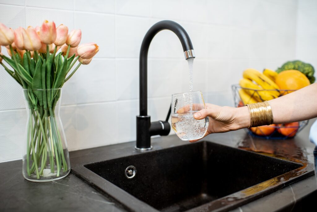 Woman filling tap water on the kitchen